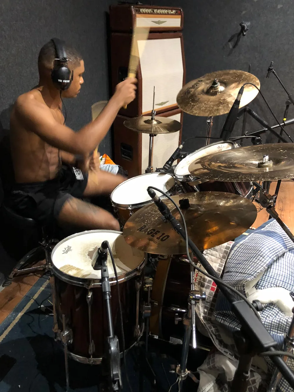 Estúdio: baterista tocando, de fones de ouvido
